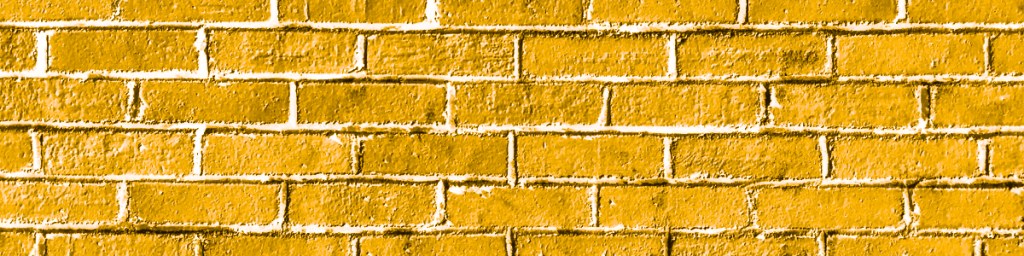 Textured yellow brick wall with visible mortar lines.